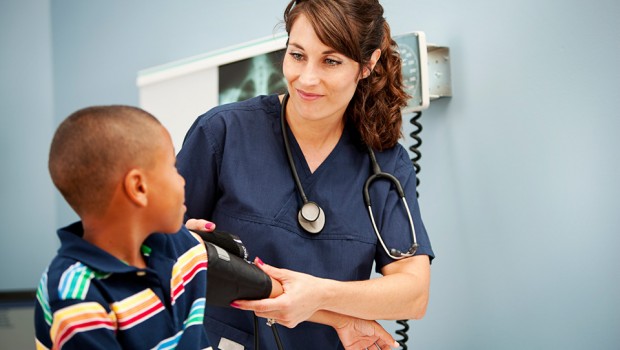 Nurse takes a young boy's blood pressure