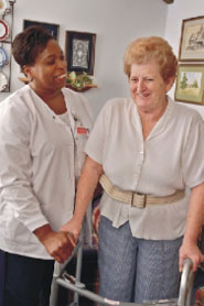 Nurse helps an elderly woman in her home