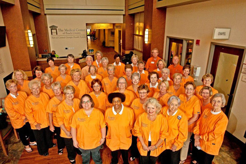 Group of volunteer ladies in peach colored shirts.